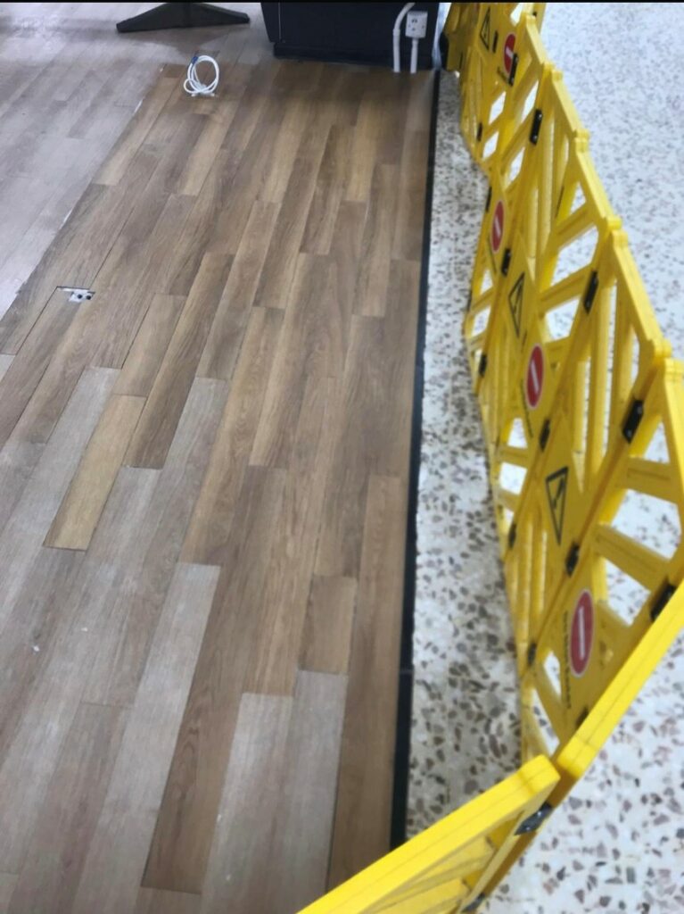 Damaged terrazzo repaired underneath vinyl flooring and fully restored in a supermarket